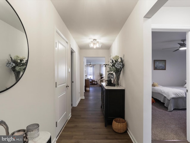 hallway with baseboards and dark wood-type flooring