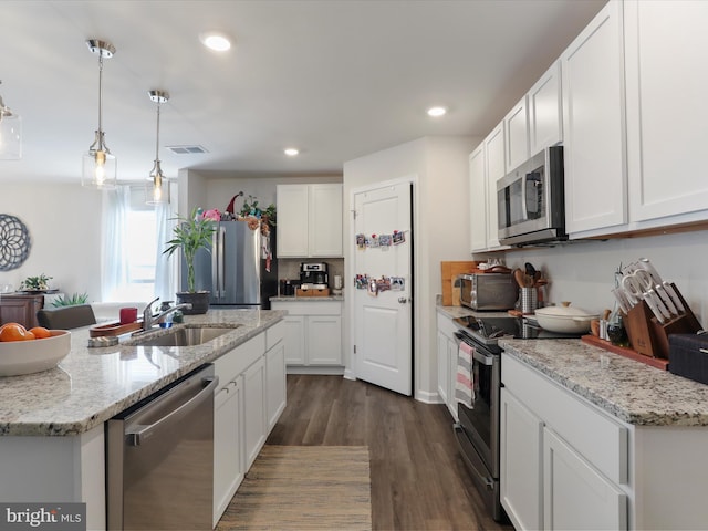 kitchen featuring dark wood-type flooring, appliances with stainless steel finishes, white cabinets, and a sink