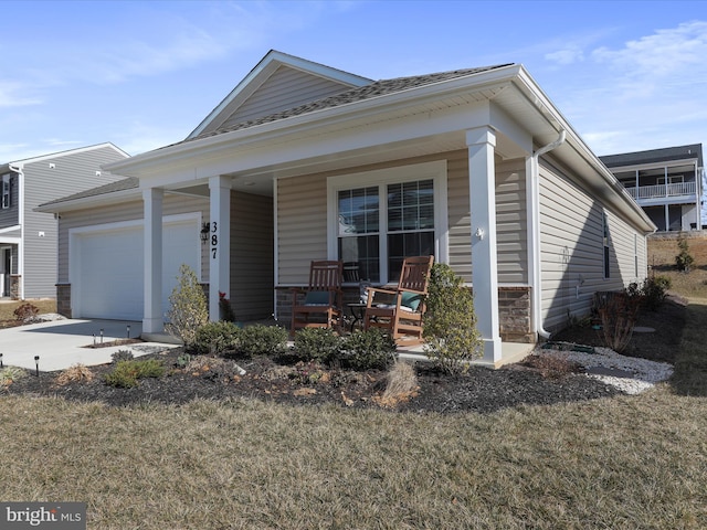 view of front of home featuring concrete driveway, a porch, and an attached garage