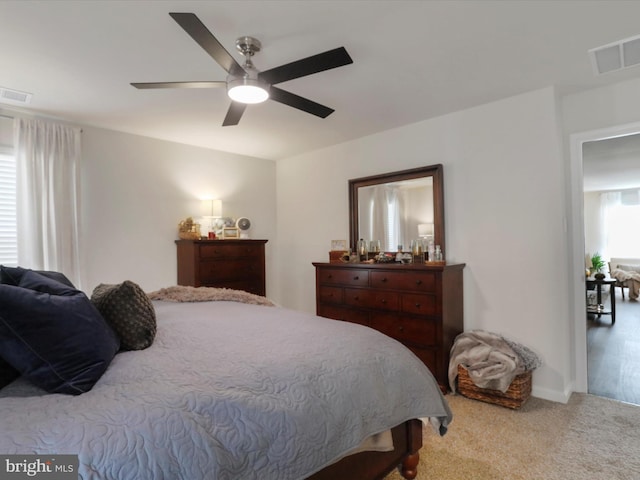 carpeted bedroom featuring visible vents and ceiling fan