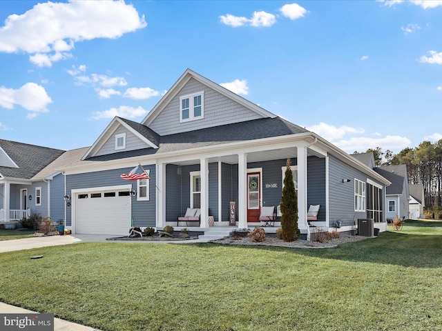 view of front facade with a porch, a garage, central AC, driveway, and a front lawn