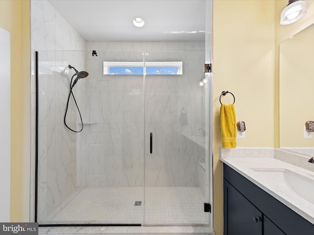 full bath with a marble finish shower and vanity