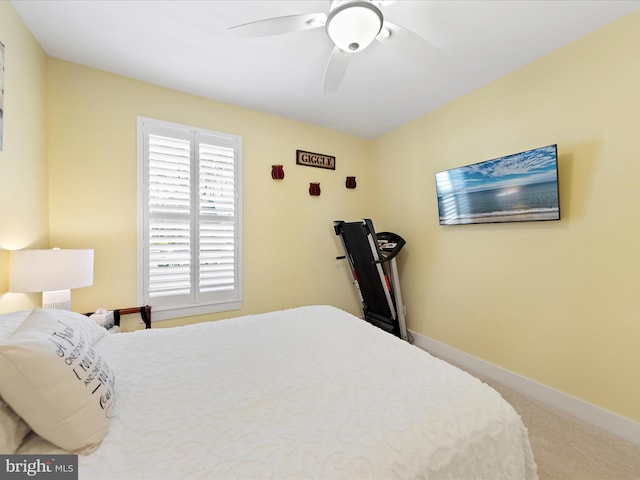 carpeted bedroom with ceiling fan and baseboards