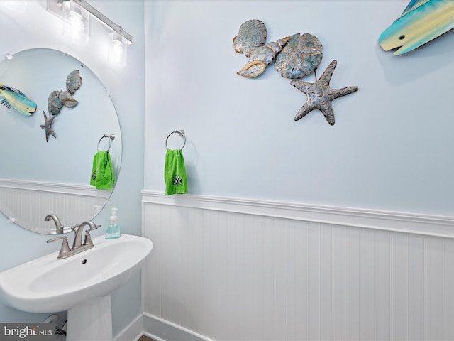 bathroom featuring a wainscoted wall and a sink