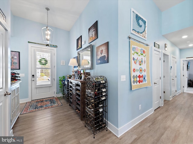 entryway with a notable chandelier, baseboards, and wood finished floors