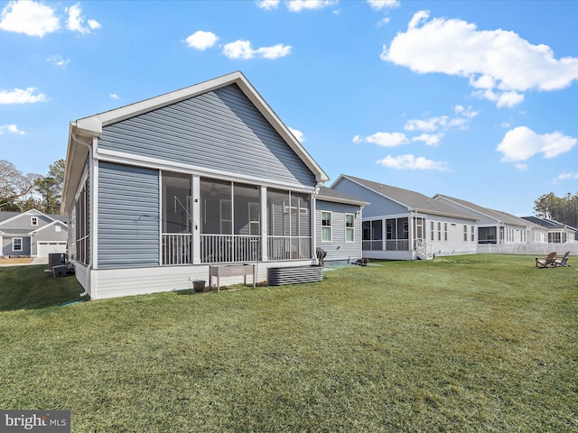 rear view of property featuring a sunroom and a lawn