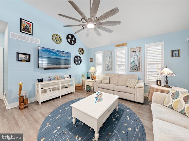 living area featuring visible vents, a ceiling fan, vaulted ceiling, wood finished floors, and baseboards