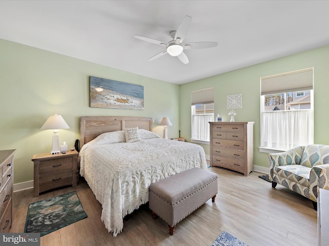 bedroom featuring ceiling fan, baseboards, and wood finished floors