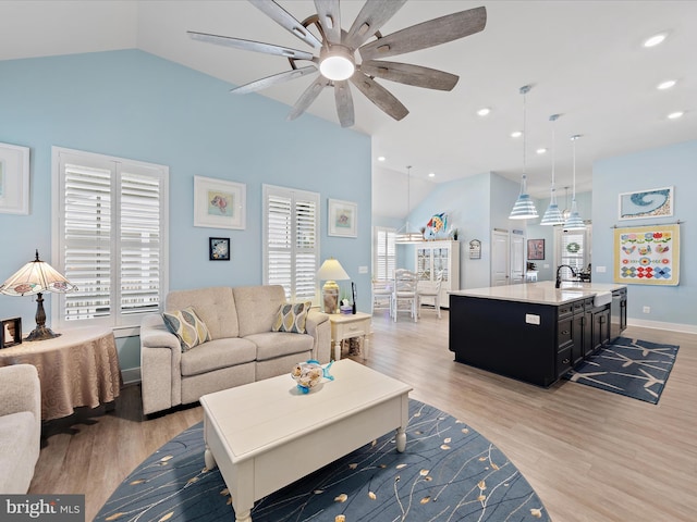 living room with lofted ceiling, recessed lighting, a ceiling fan, and light wood-style floors