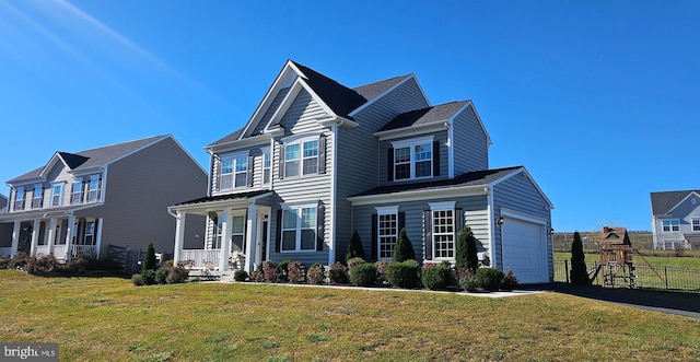 traditional-style home with a garage, aphalt driveway, a front yard, and fence