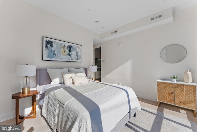 bedroom with light wood-style floors, baseboards, and visible vents