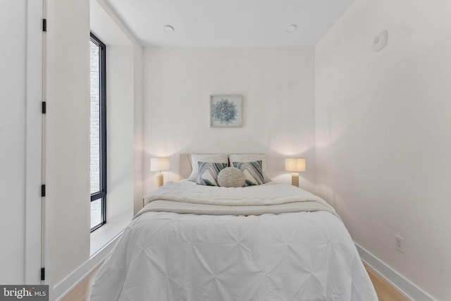 bedroom with light wood-type flooring and baseboards