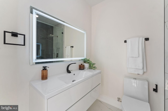 bathroom with a marble finish shower, baseboards, toilet, marble finish floor, and vanity