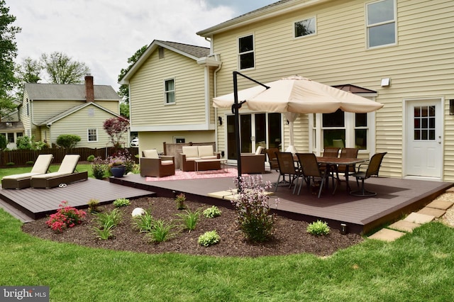 back of house with a yard, outdoor lounge area, fence, and a deck