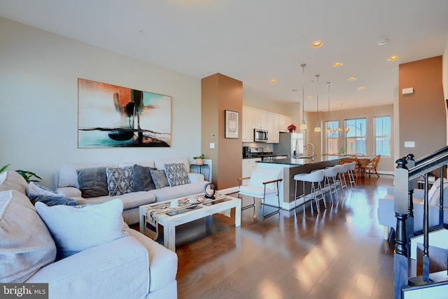 living room featuring dark wood-style floors, recessed lighting, baseboards, and stairs