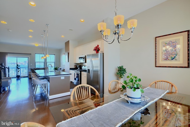 dining room with dark wood-style floors, recessed lighting, and an inviting chandelier