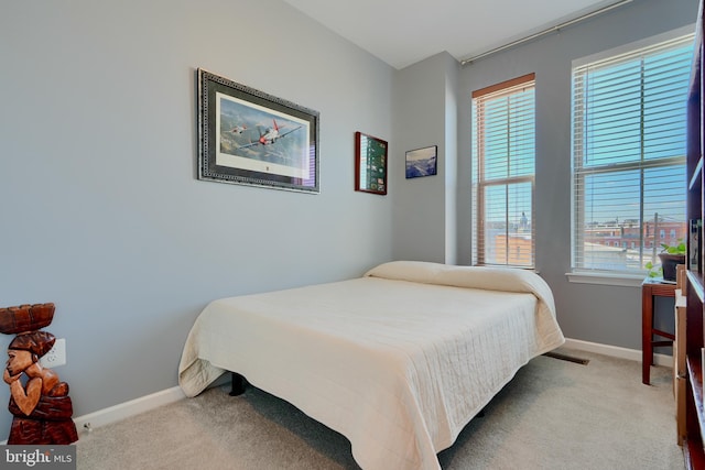 bedroom with multiple windows, carpet, and baseboards