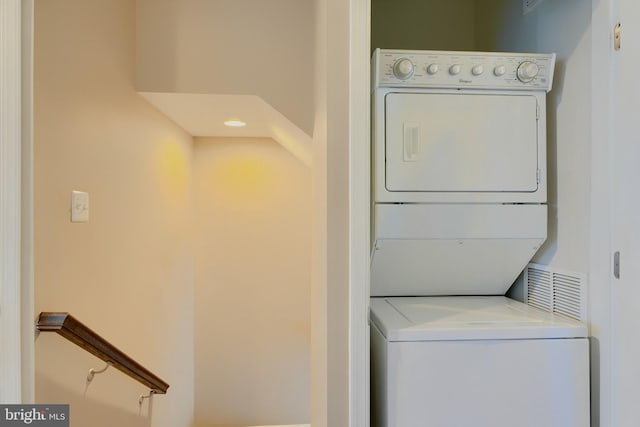 laundry room with visible vents, laundry area, and stacked washer and clothes dryer