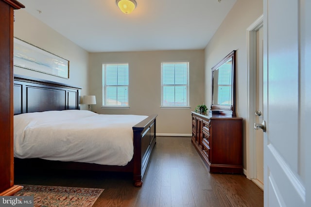 bedroom with baseboards and dark wood finished floors