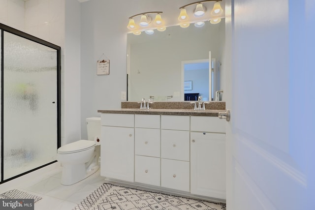 bathroom with toilet, a stall shower, double vanity, and a sink