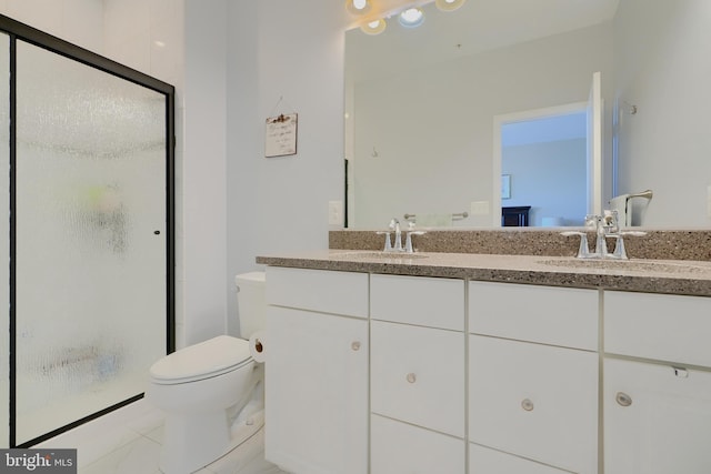 bathroom featuring double vanity, a sink, toilet, and a shower stall