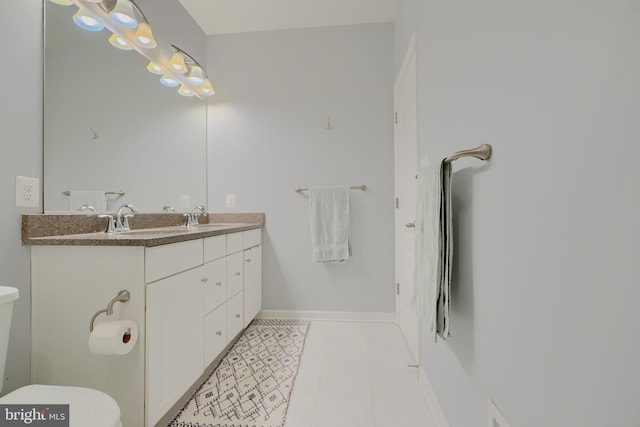 bathroom featuring toilet, a sink, and tile patterned floors