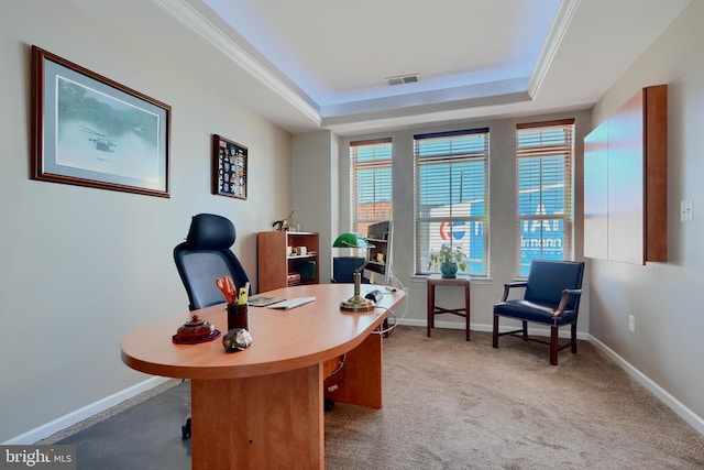 office with baseboards, visible vents, a raised ceiling, ornamental molding, and carpet