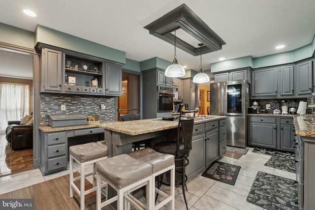 kitchen with a center island, gray cabinets, smart refrigerator, and light stone countertops