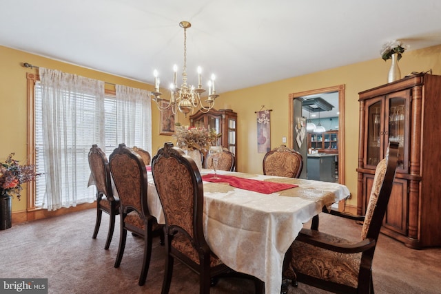 dining room with a chandelier and carpet