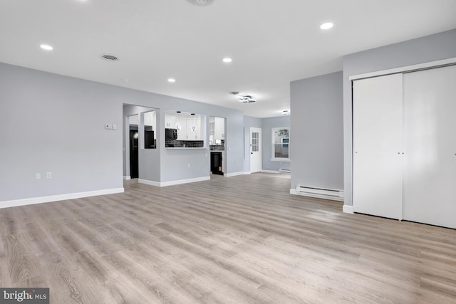 unfurnished living room with recessed lighting, visible vents, light wood finished floors, and baseboard heating