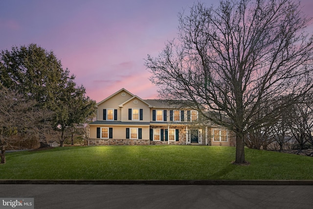 view of front of home featuring stone siding and a front lawn