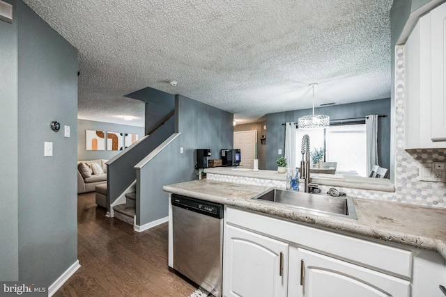 kitchen featuring white cabinetry, light countertops, dishwasher, and decorative light fixtures