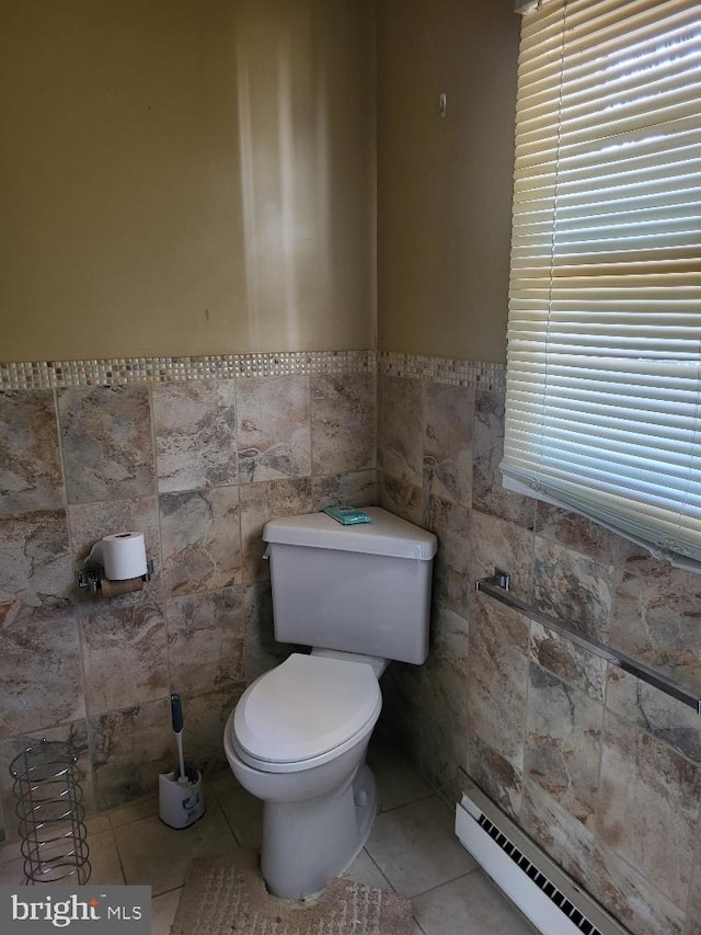 bathroom featuring toilet, a wainscoted wall, tile patterned flooring, baseboard heating, and tile walls