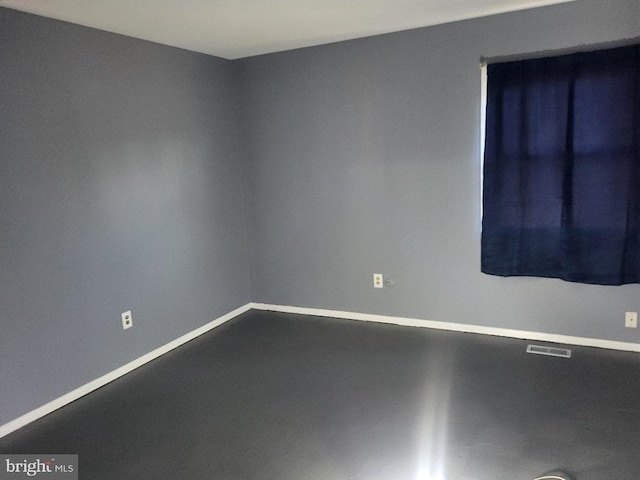 empty room featuring baseboards, visible vents, and concrete flooring