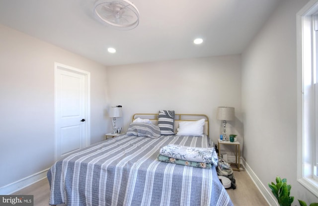 bedroom with baseboards, wood finished floors, and recessed lighting