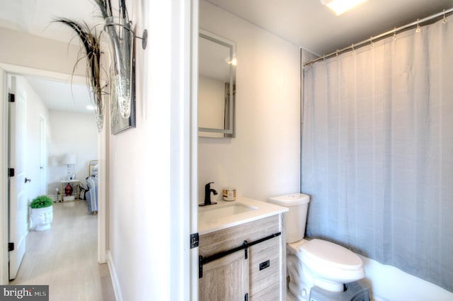 bathroom with a shower with shower curtain, vanity, and toilet