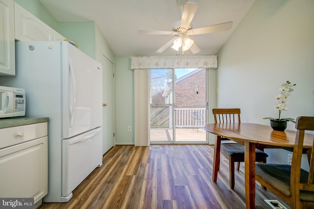 dining space featuring dark wood-style flooring and ceiling fan