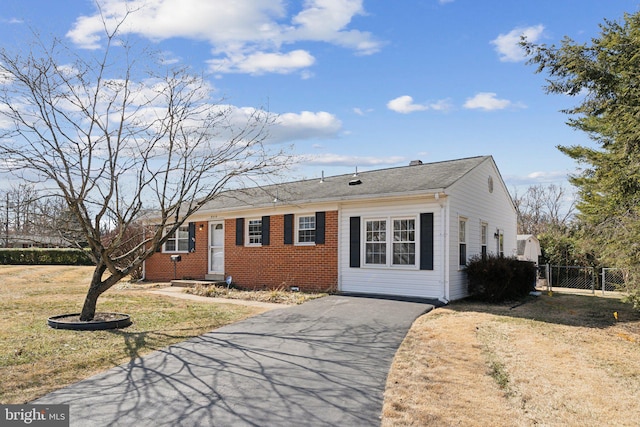 single story home with a gate, fence, aphalt driveway, and brick siding