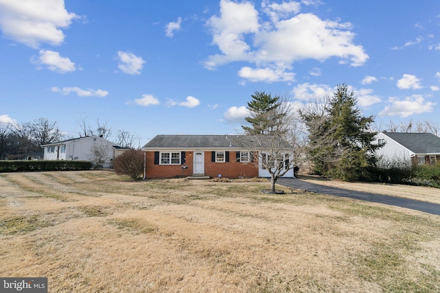 ranch-style house featuring driveway, brick siding, and a front yard