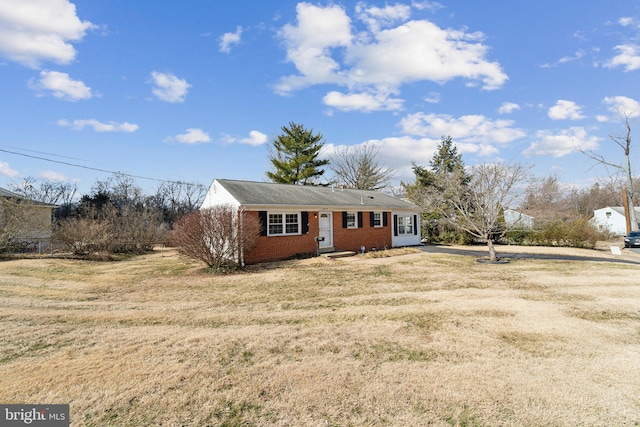 view of front of house featuring brick siding and a front yard