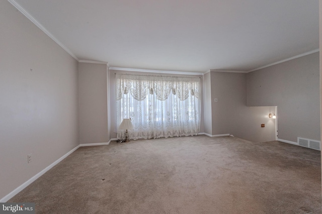 carpeted spare room featuring baseboards, visible vents, and ornamental molding