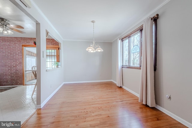 unfurnished dining area featuring crown molding, light wood finished floors, baseboards, and brick wall