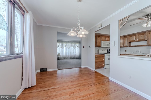 kitchen with white appliances, baseboards, ornamental molding, light wood-style floors, and ceiling fan with notable chandelier