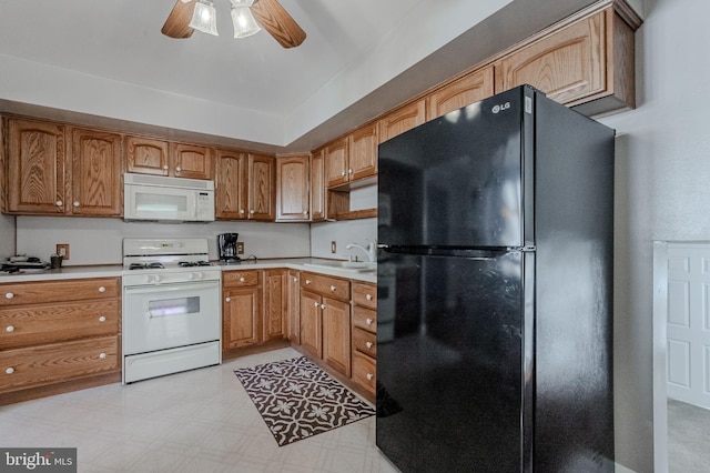 kitchen with light floors, white appliances, light countertops, and a sink