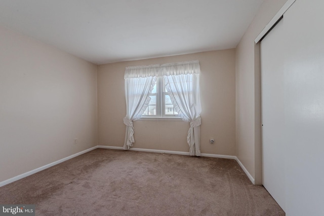 carpeted empty room with baseboards