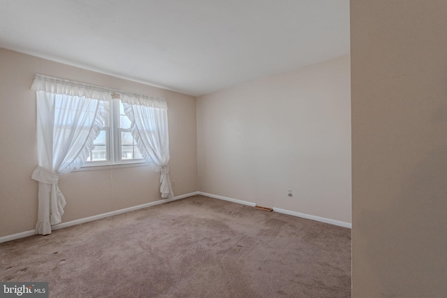 carpeted spare room with baseboards