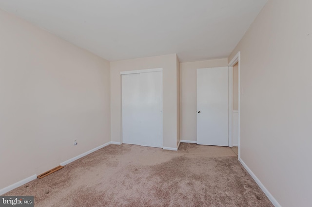 unfurnished bedroom featuring baseboards, visible vents, and carpet floors