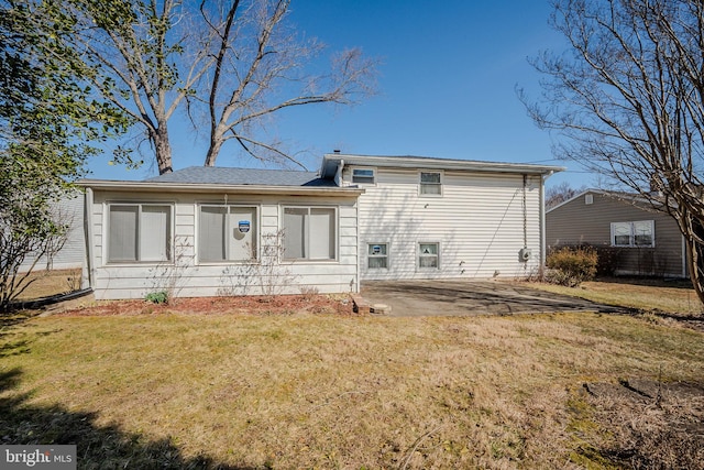 rear view of house featuring a yard and a patio area