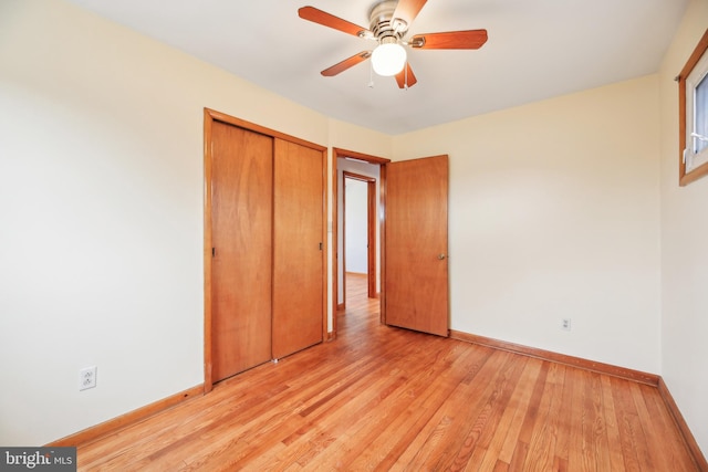 unfurnished bedroom featuring ceiling fan, a closet, light wood-style flooring, and baseboards