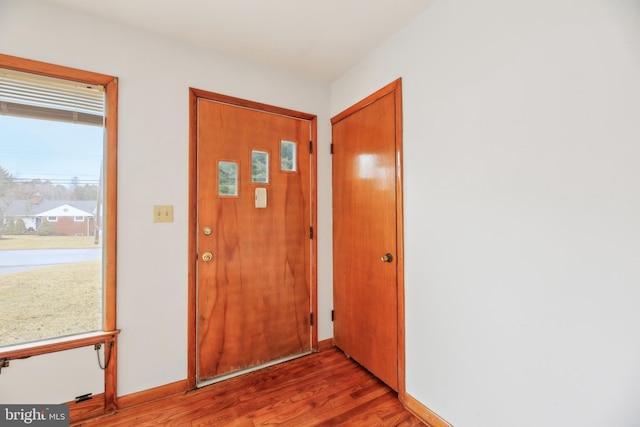 doorway to outside featuring light wood-style flooring and baseboards